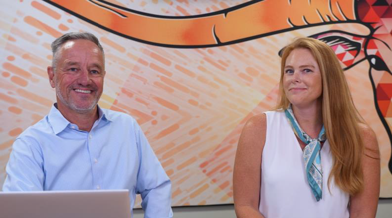 two people in front of a mural