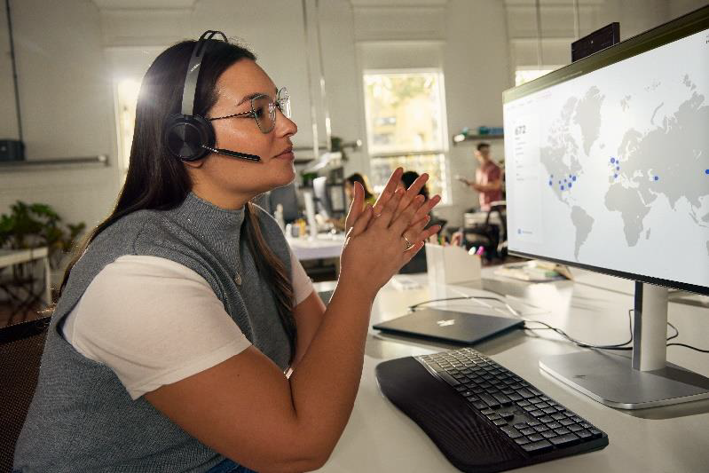 A person wearing a headset and talking on her phone